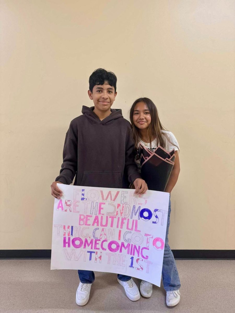 Chelsea Abdalla and David Ramirez-Orellana holding a homecoming proposal sign