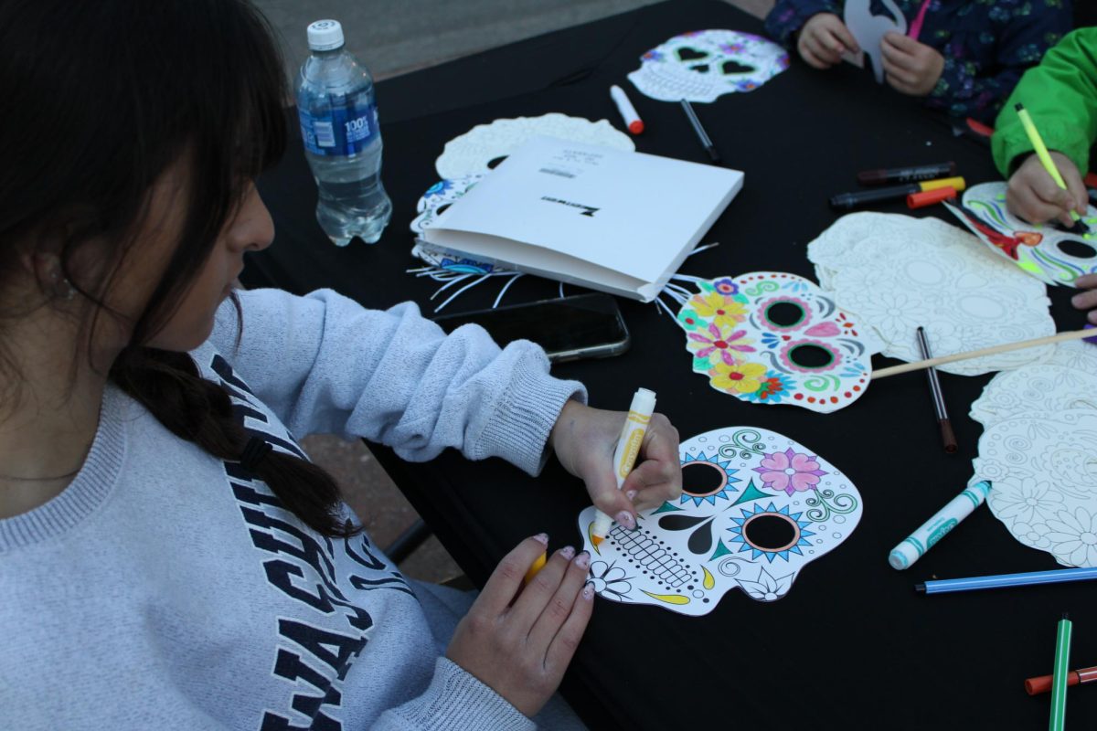 Freshman Maddie Woody volunteers at the Key Club table during the Dia De Los Muertos event at Placer High School.