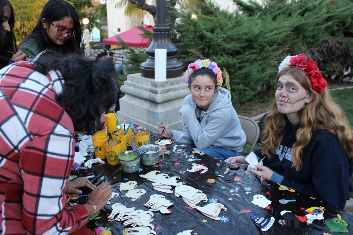 Olivia Ornelas and Reagan Browning help make decorations at Placer's Día de los Muertos event.